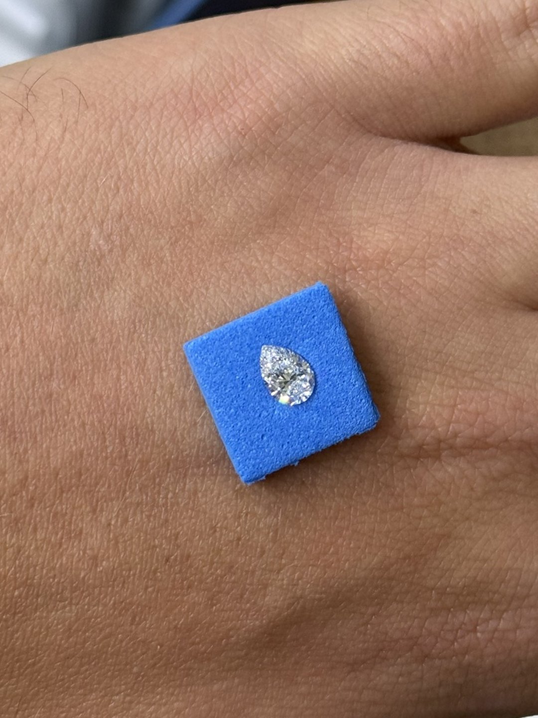 Il diamante a goccia appoggiato sul dorso della mano, su un tampone blu